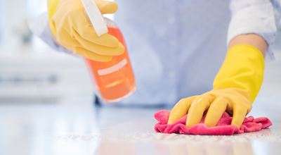 Person cleaning countertop with cleaning gloves
