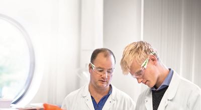 Two Nouryon employees at work with lab coat and safety glasses